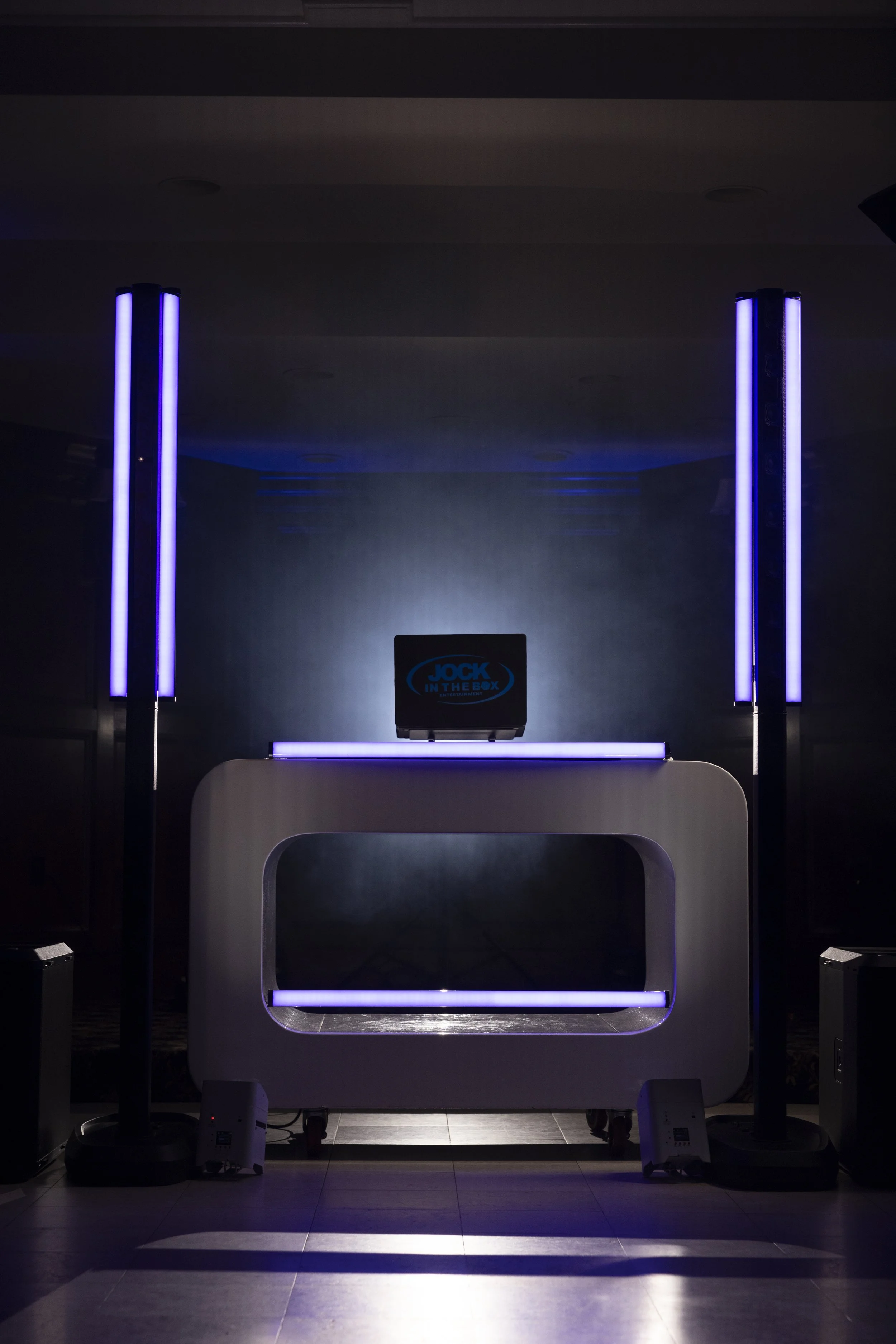 Intelligent lighting rig flanking the custom DJ booth